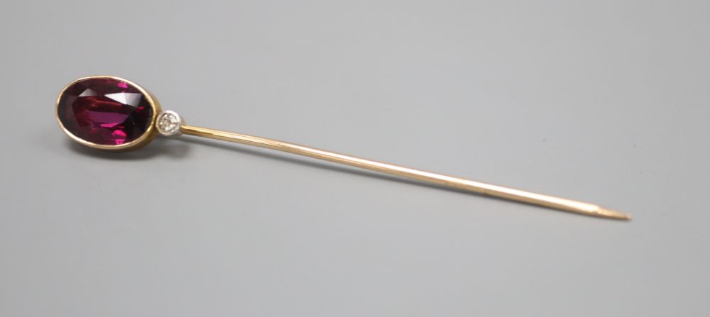 An Edwardian yellow metal, garnet and diamond set stick pin, 64mm, gross 2.2 grams.